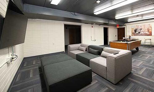 a common area with a couch, pool table and TV.